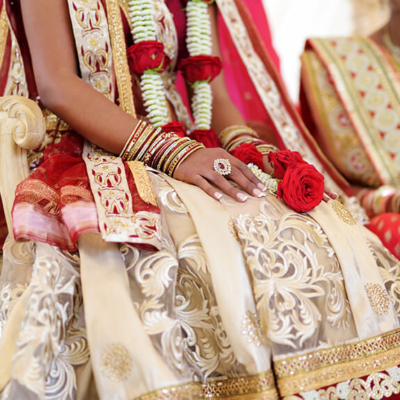 close-up of indian bride's hands wearing traditional garment