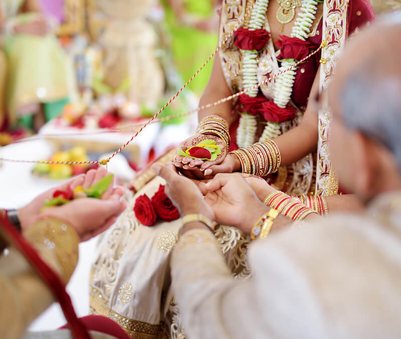 indian bride in beautiful traditional wedding dress holding ceremonial items in her hands