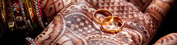 bride's hands with henna painted on and two gold wedding bands