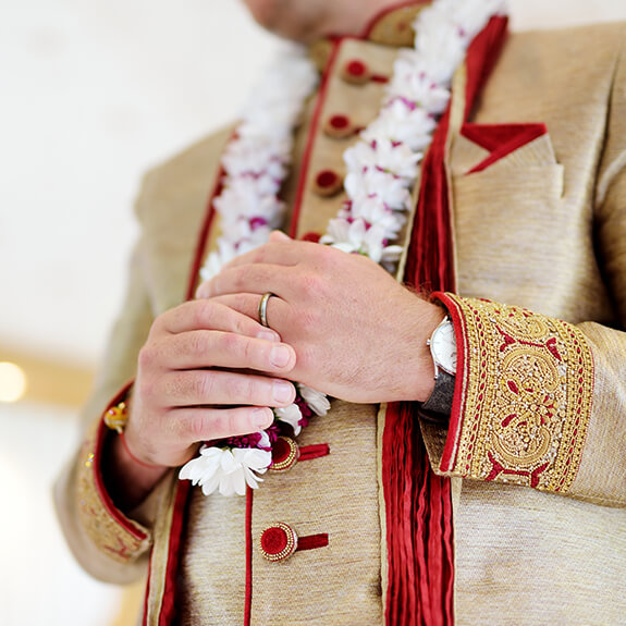 close-up of indian groom's hands in traditional attire