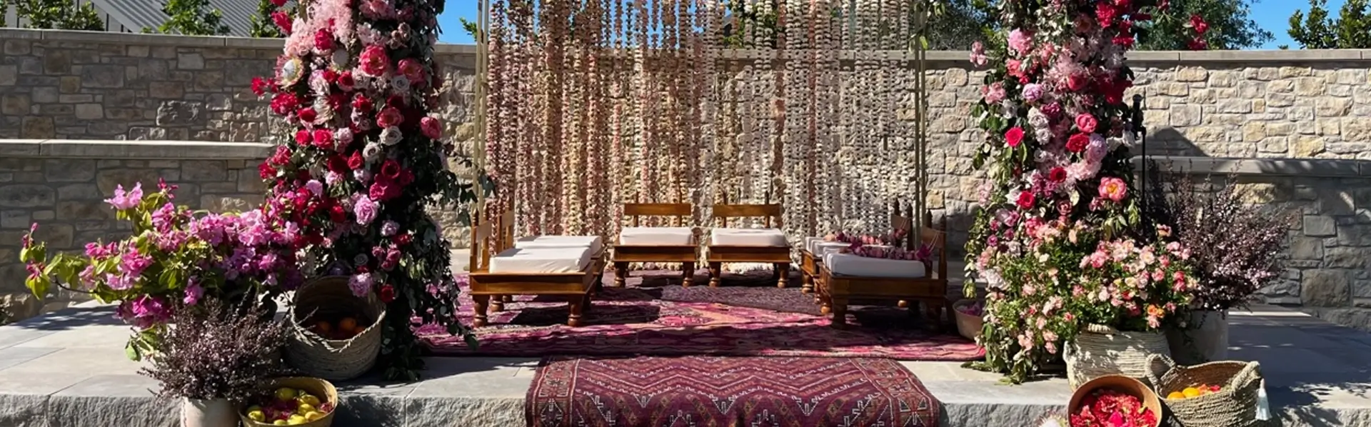 colorful Mehndi Haldi and Sangeet décor rentals in California featuring Indian seating textiles flowers and festive backdrops